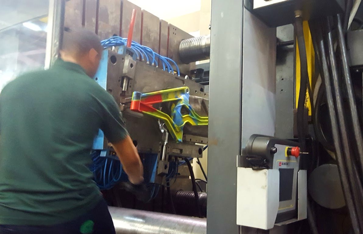 Quadro de bicicleta multicolorido saindo do molde da máquina injetora